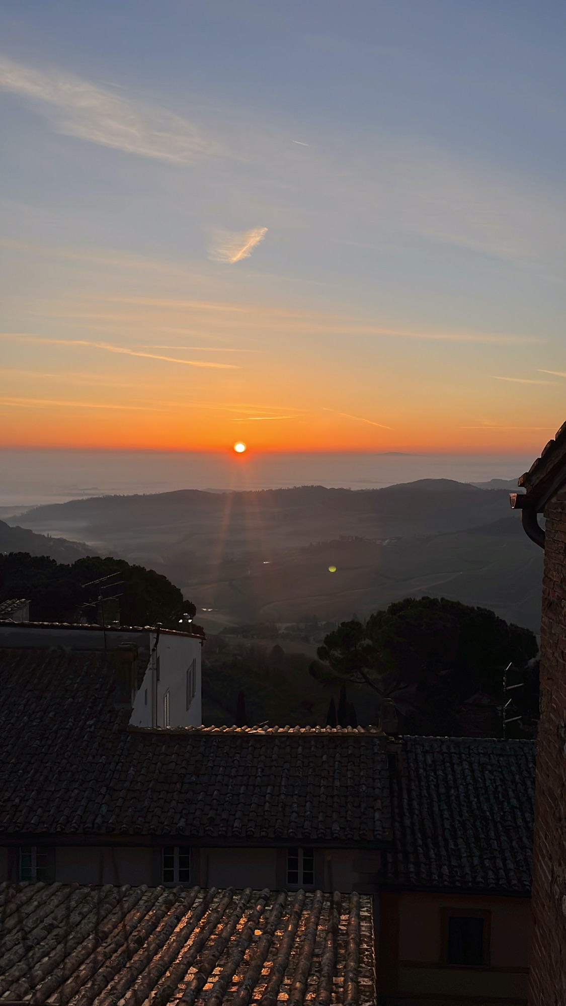 Sunset view over rooftops and rolling hills from Montepulciano, Tuscany