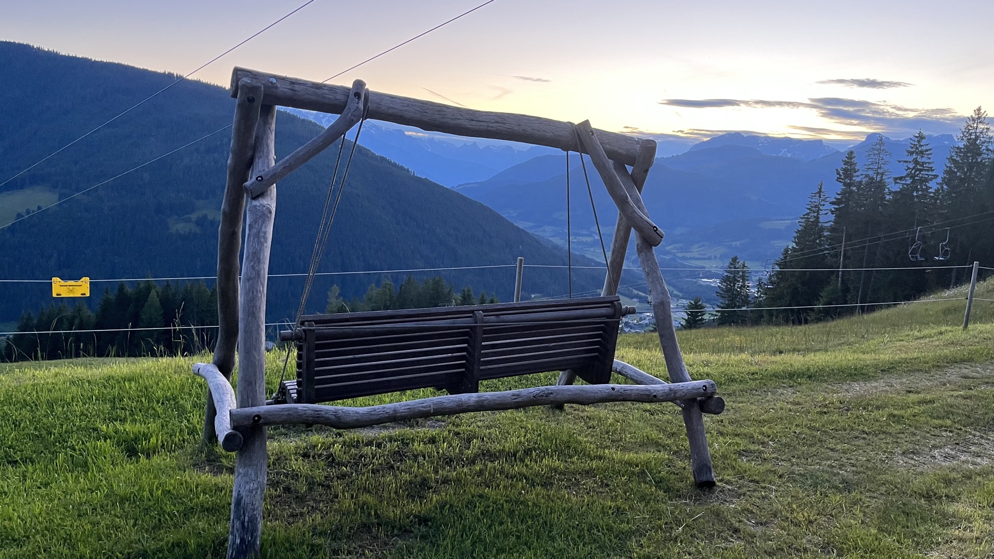 Wooden swing overlooking a misty mountain valley in Austria